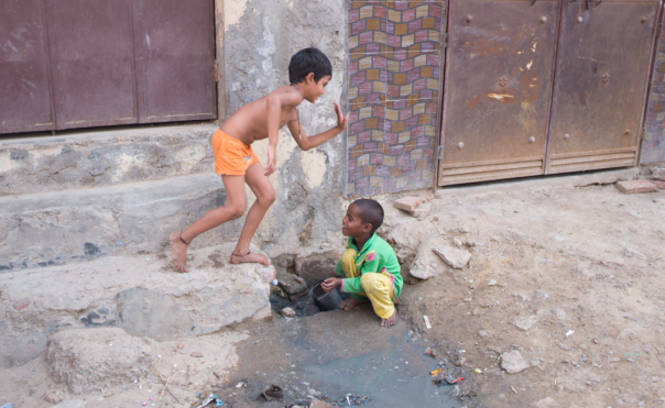 Kids playing in an open sewer.